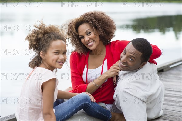 Family smiling on wooden dock