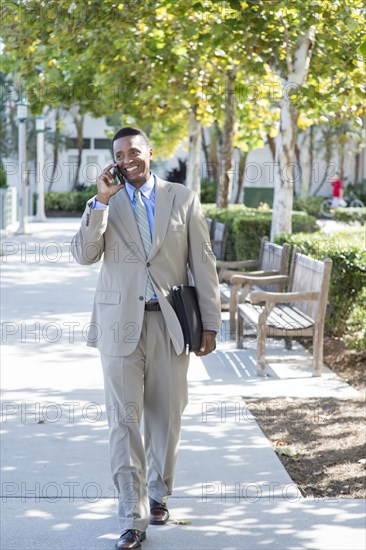 Black businessman talking on cell phone outdoors