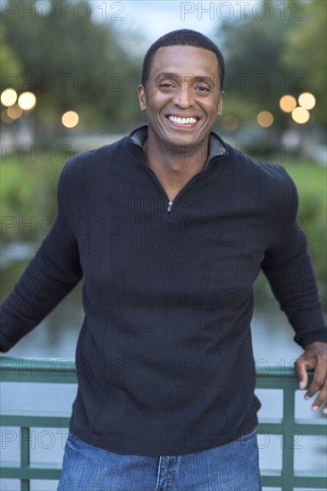 Black man standing on bridge