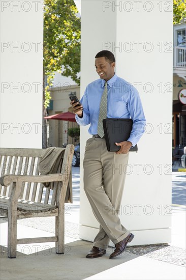 Black businessman using cell phone outdoors