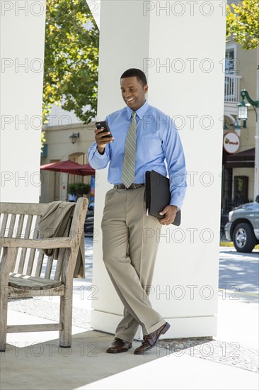 Black businessman using cell phone outdoors