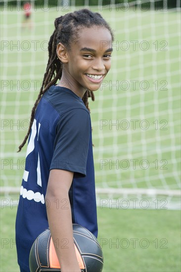 Mixed race boy playing soccer