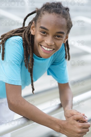 Mixed race boy smiling on bleachers
