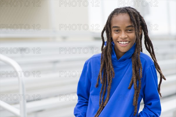 Mixed race boy smiling on bleachers