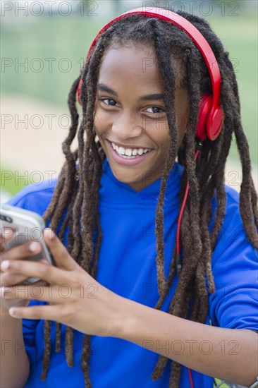 Mixed race boy using cell phone outdoors