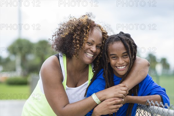Mixed race mother and son hugging outdoors