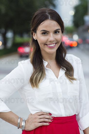 Hispanic businesswoman smiling outdoors