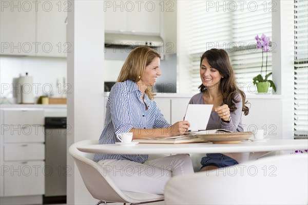 Caucasian women using digital tablet in kitchen