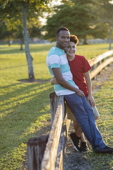 Father and son hugging at fence