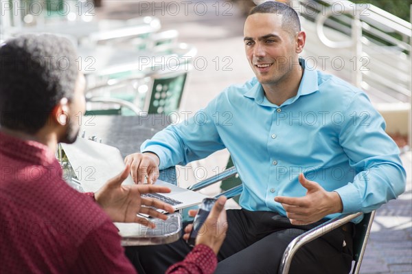 Businessmen talking in cafe