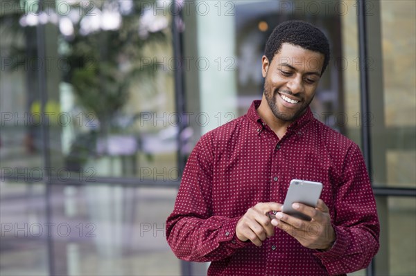 Black businessman using cell phone outdoors