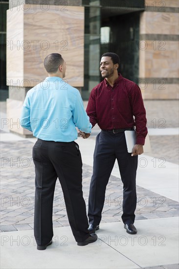 Businessmen shaking hands outdoors