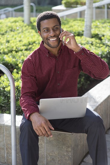 Black businessman talking on cell phone outdoors