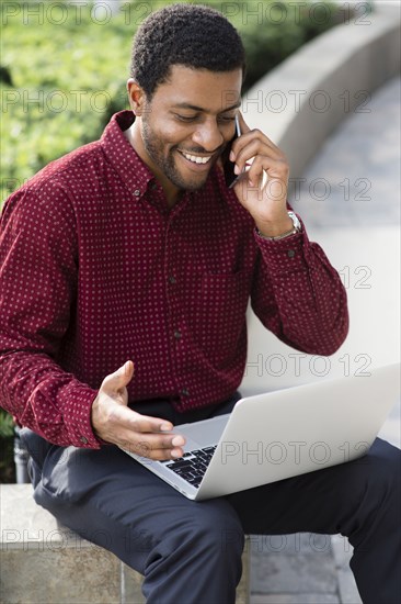 Black businessman talking on cell phone outdoors