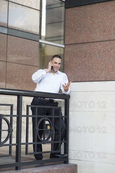 Caucasian businessman talking on cell phone outdoors