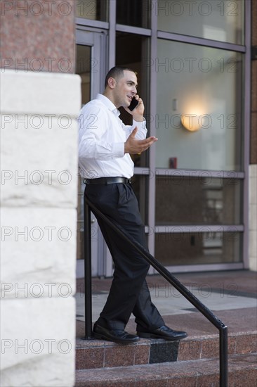 Caucasian businessman talking on cell phone outdoors