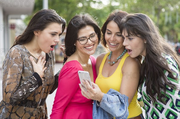 Hispanic women using cell phone outdoors