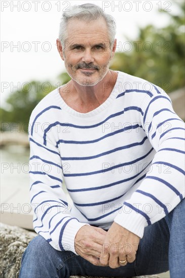 Older Caucasian man sitting outdoors