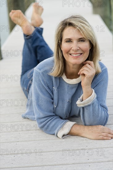 Older Caucasian woman laying on pier