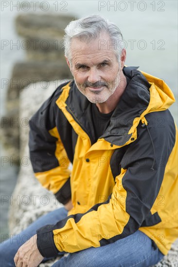 Older Caucasian man sitting outdoors