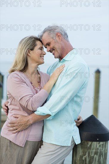 Older Caucasian woman hugging on pier