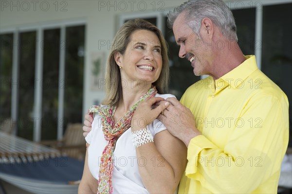 Older Caucasian couple hugging outdoors