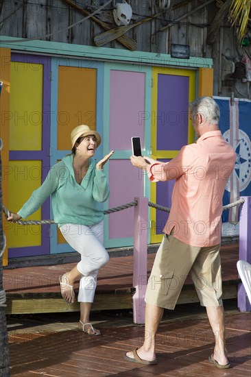 Older Caucasian man photographing wife