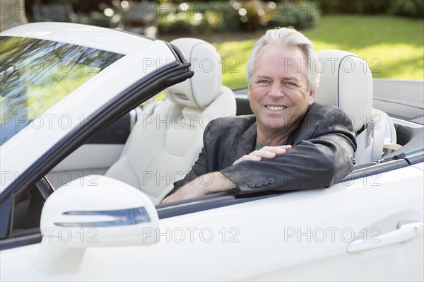 Caucasian man smiling in convertible