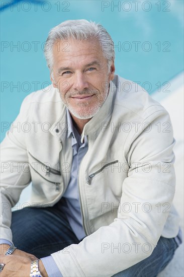 Caucasian man sitting poolside