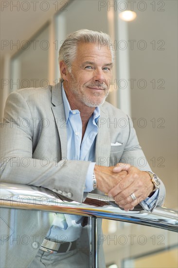 Smiling Caucasian man leaning on railing