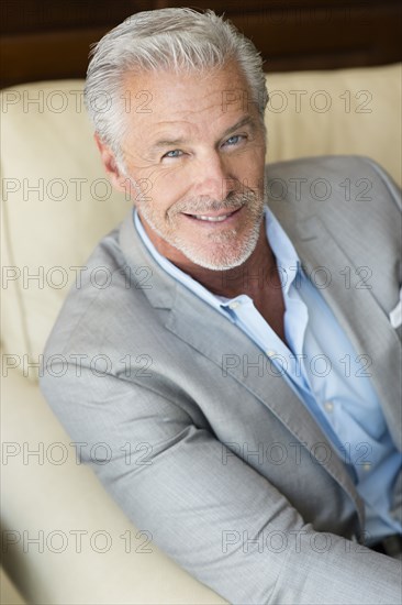 Smiling Caucasian man sitting on sofa