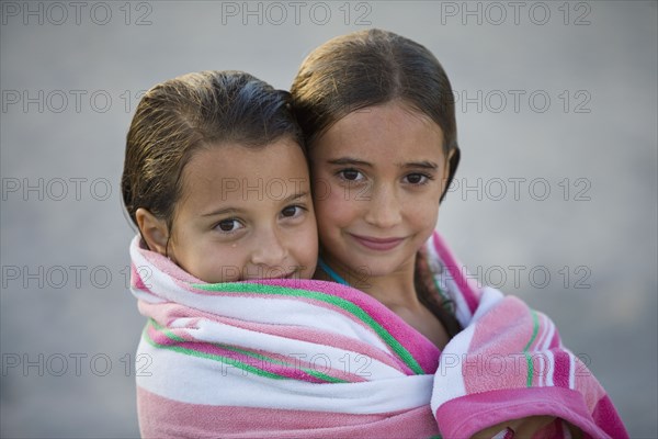 Close up Hispanic girls wrapped in towel together