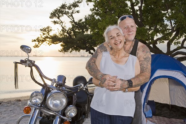 Mother and tattooed son camping at the beach