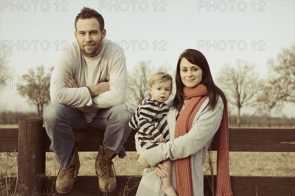 Caucasian family standing near wooden fence