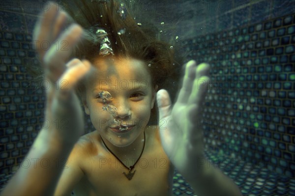 Boy swimming underwater in swimming pool