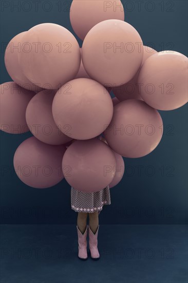 Caucasian girl holding large balloons