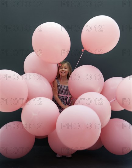 Caucasian girl holding large balloons
