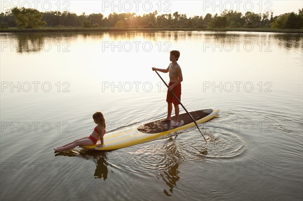 Children on paddleboard on lake