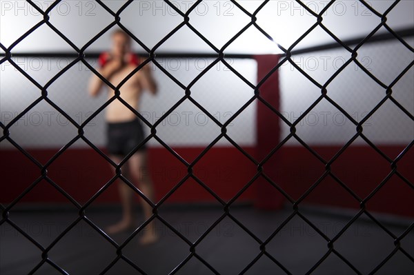 Caucasian cage fighter standing in cage