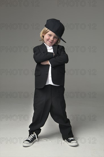 Caucasian boy posing in oversized suit