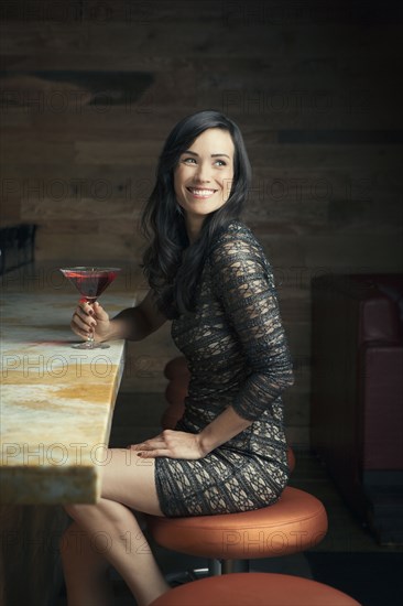 Hispanic woman smiling at bar