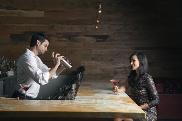 Hispanic woman having drink at bar