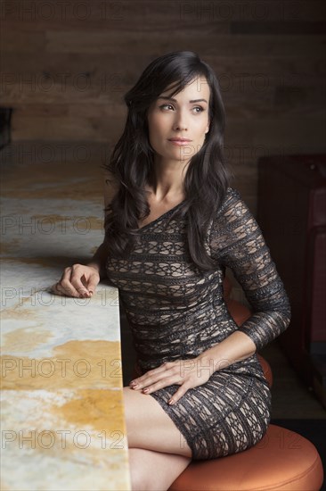 Hispanic woman sitting at bar