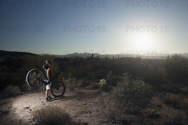 Mountain biker standing in desert