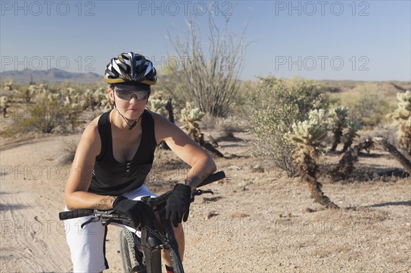 Woman riding mountain bike in desert