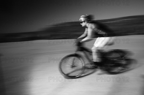 Woman riding mountain bike in desert