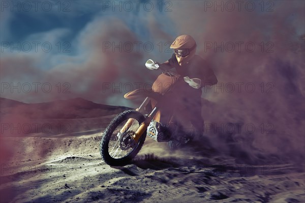 Caucasian man riding dirt bike in dust cloud
