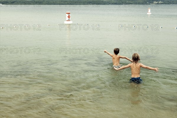 Caucasian boys swimming in lake
