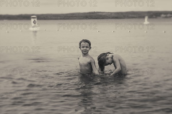 Caucasian boys swimming in lake