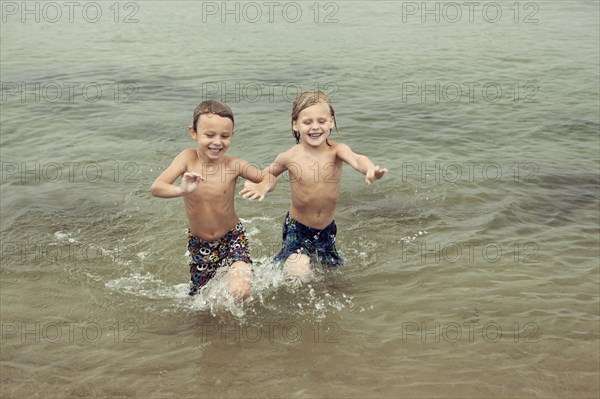 Caucasian boys playing in lake